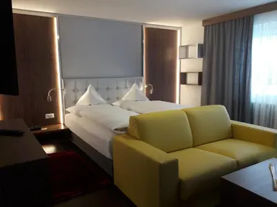 a hotel room with a large bed and a couch at Ruster Resort in Lagundo