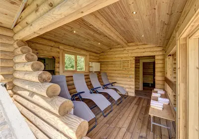 a room with chairs in a log cabin at Ruster Resort in Lagundo