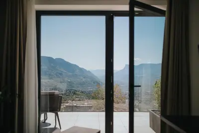 a view of a mountain from a room with sliding glass doors at La Vista Panoramic Hideaway - Adults only in Tirolo