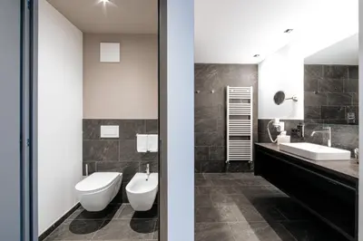 two views of a bathroom with a toilet and a sink at La Vista Panoramic Hideaway - Adults only in Tirolo