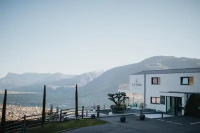 a white building with mountains in the background at La Vista Panoramic Hideaway - Adults only in Tirolo