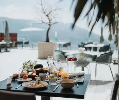 a table with plates of food and drinks on it at La Vista Panoramic Hideaway - Adults only in Tirolo