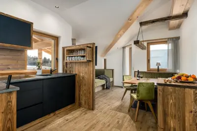 a kitchen and dining room with a table and chairs at Forchnerhof Nature & Mountain View Apartments in Terento