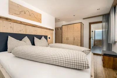 a bedroom with two beds and a window at Forchnerhof Nature & Mountain View Apartments in Terento