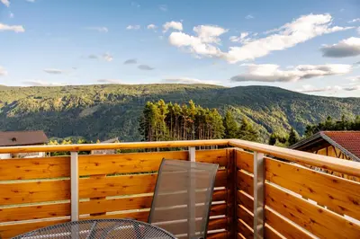 a balcony with a table and chairs and mountains at Forchnerhof Nature & Mountain View Apartments in Terento