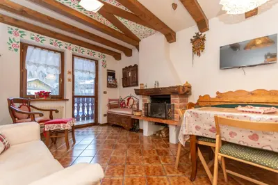 a living room with a table and a fireplace at Chalet Kalipe in Rocca Pietore