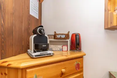 a microwave sitting on top of a wooden dresser at Chalet Kalipe in Rocca Pietore