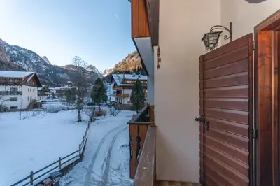 a balcony with a door and a snowy street at Chalet Kalipe in Rocca Pietore