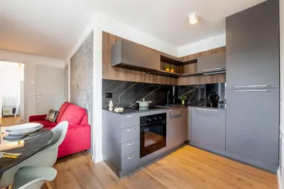 a kitchen with a red couch and a table at GuestHost - Dolomite Elegance - Chic Flat in San Vito di Cadore in Termine