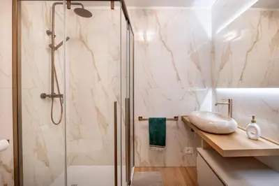 a bathroom with a shower and a sink at GuestHost - Dolomite Elegance - Chic Flat in San Vito di Cadore in Termine