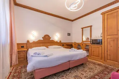 a bedroom with a large bed and a mirror at Suite Tre Cime in Alleghe
