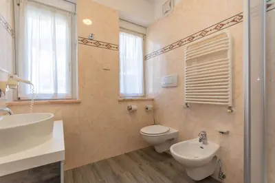 a bedroom with a large bed with white sheets at Suite Tre Cime in Alleghe