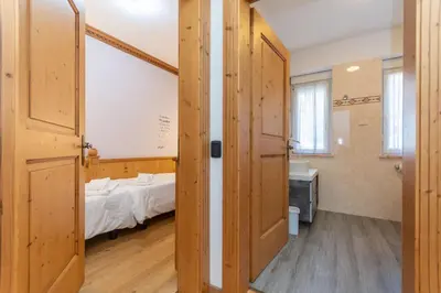 a bedroom with a large bed with a wooden headboard at Suite Tre Cime in Alleghe