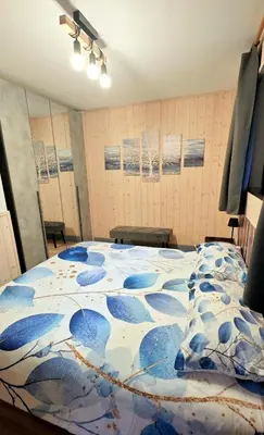 a bedroom with a bed with paintings on the wall at Casa Cermis in Cavalese