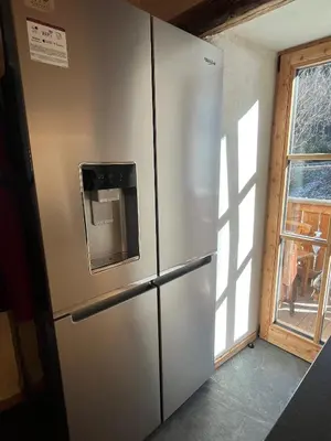 a stainless steel refrigerator in a room with a window at Casa Alice in Rocca Pietore