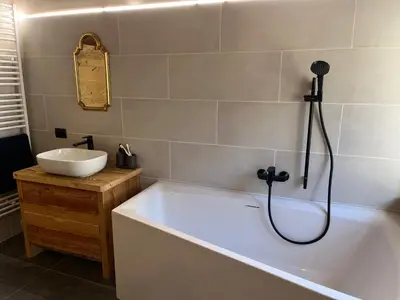 a bathroom with a bath tub and a sink at Casa Alice in Rocca Pietore