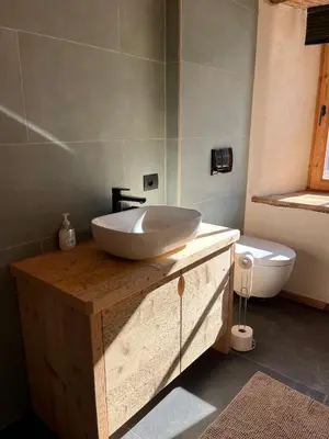 a bathroom with a white sink on a wooden counter at Casa Alice in Rocca Pietore