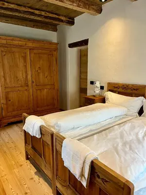 two beds in a bedroom with wooden cabinets at Casa Alice in Rocca Pietore