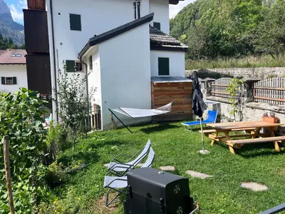 a backyard with a table and a picnic table and a bench at Casa Alice in Rocca Pietore