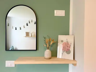 a mirror and a vase on a shelf with a picture at Haslingerhof - Ferienwohnung Hirzer in Saltusio