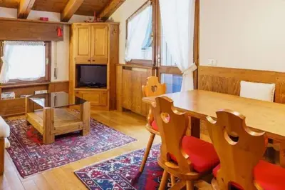 a dining room with a table and chairs and a tv at Cà Masariè Alverà in Cortina dʼAmpezzo