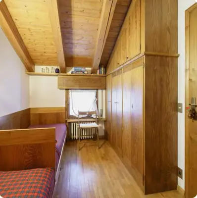 a room with a bed and a wooden ceiling at Cà Masariè Alverà in Cortina dʼAmpezzo