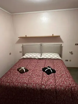 a bedroom with a bed with two slippers on it at SASS MAOR 2 bedrooms apartment 80 sm Fiera di Primiero TN in Fiera di Primiero