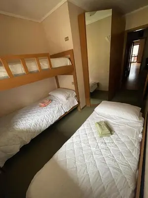 a bedroom with two bunk beds and a mirror at SASS MAOR 2 bedrooms apartment 80 sm Fiera di Primiero TN in Fiera di Primiero