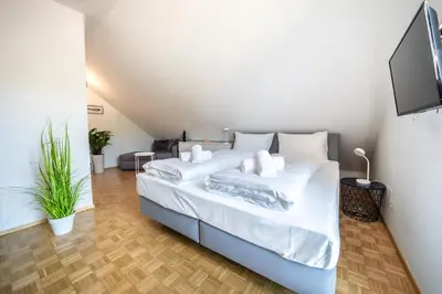a bedroom with a large bed with white sheets at Am See Apartments in Castelvecchio