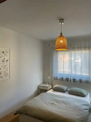 a bedroom with a bed with a lamp and a window at Haus Stadler in Naturno