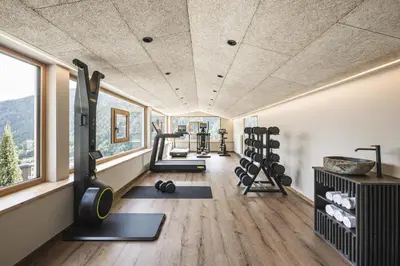a gym with several treadmills and weights in a room at Falkensteiner Hotel Falkensteinerhof l 4 Star Superior in Valles