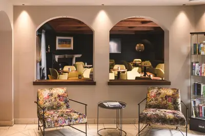two chairs in a waiting room with mirrors at Falkensteiner Hotel Falkensteinerhof l 4 Star Superior in Valles