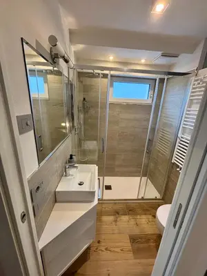 a bathroom with a white sink and a shower at Pragma Apartments - Fiore delle Alpi in Bellamonte
