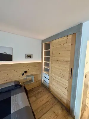 a room with a closet with a wooden door at Pragma Apartments - Fiore delle Alpi in Bellamonte