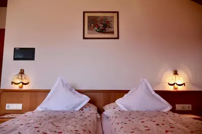 two beds in a hotel room with white pillows at Oberortsgut in Tirolo