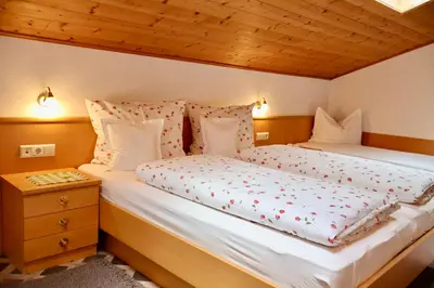 a bedroom with two beds and a wooden ceiling at Oberortsgut in Tirolo