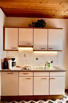 a kitchen with white cabinets and a sink at Oberortsgut in Tirolo