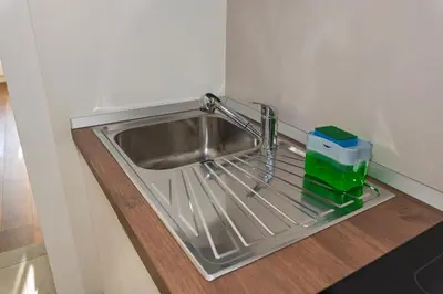 a stainless steel sink in a corner of a kitchen at Appartamento Alpino Cles in Cles