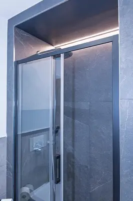 a shower with a glass door in a bathroom at Appartamento Alpino Cles in Cles