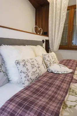 a bedroom with a bed with pillows on it at Appartamento Alpino Cles in Cles