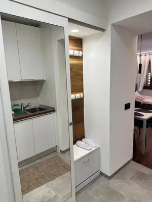 a small kitchen with white cabinets and a sink at Appartamento Alpino Cles in Cles