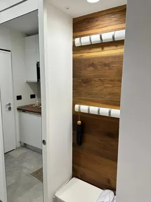a bathroom with a toilet and a wooden wall at Appartamento Alpino Cles in Cles