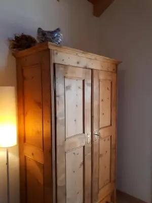 a wooden cabinet in a room next to a lamp at Ferienwohnungen Hofanger in Lagundo