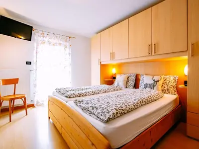 a bedroom with a bed and a red couch at Apartment Delago by Interhome in Pera