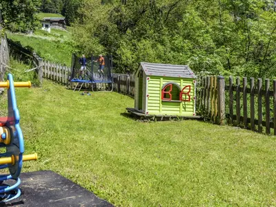 two children playing on a playground with a slide at Apartment El Ladinia-2 by Interhome in Moena