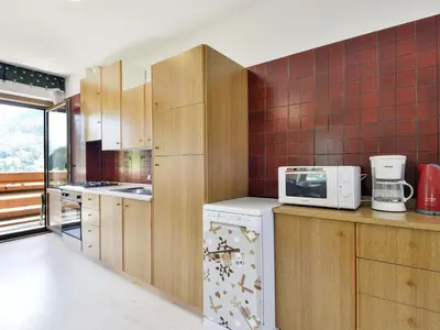 a kitchen with a microwave and a refrigerator at Apartment El Ladinia-2 by Interhome in Moena