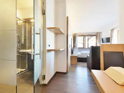a bedroom with a bed and a sink and a television at Holiday Home Kostner-2 by Interhome in Bulla