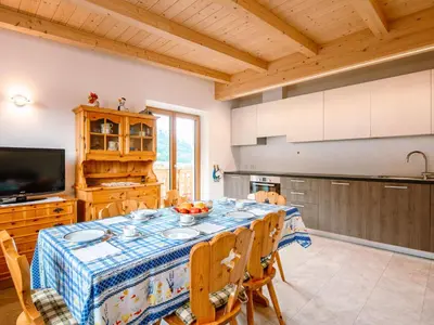 a kitchen with wooden cabinets and a large window at Apartment Saslench by Interhome in Pera