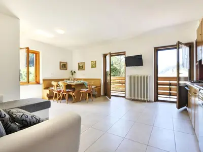 a kitchen and living room with a table and chairs at Apartment El Ladinia-1 by Interhome in Moena