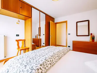 a bedroom with a large bed and a mirror at Apartment Stabler by Interhome in Pera